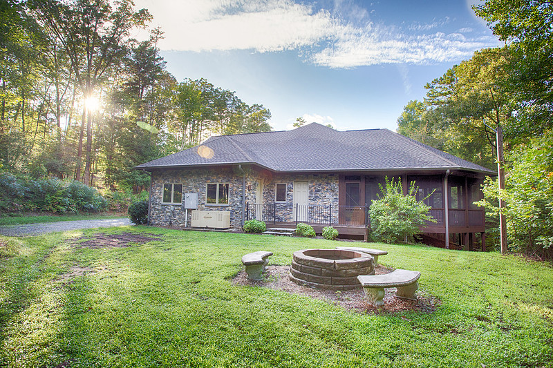Backyard of a ranch home with a fire pit and lawn, real estate photography in North Georgia