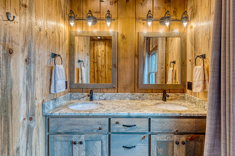 Rustic bathroom with a double vanity and wood walls, real estate photography in North Georgia