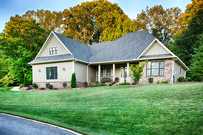 Front exterior of a white craftsman home with a green lawn, real estate photography in North Georgia