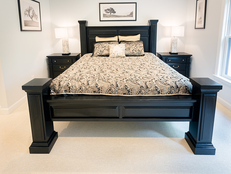Bright primary bedroom with a dark wood bed, real estate photography in North Georgia