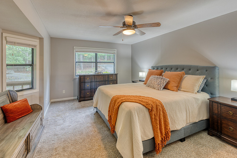 Guest bedroom with neutral decor and a ceiling fan, real estate photography in North Georgia