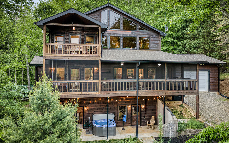Rear exterior of a mountain cabin with covered decks, real estate photography in North Georgia