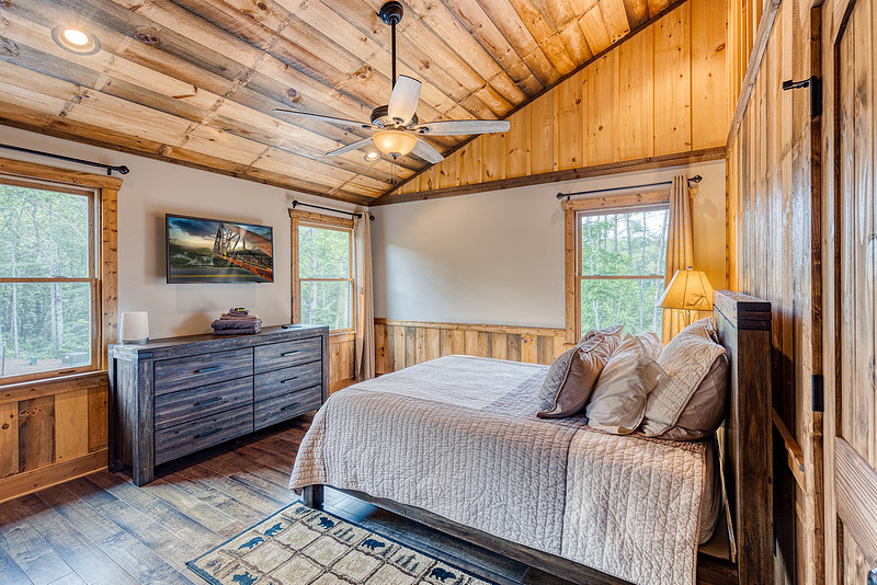 Bedroom with a wood ceiling and mountain cabin decor, real estate photography in North Georgia