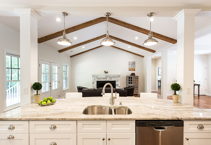 Bright white kitchen with an island and vaulted beamed ceiling, real estate photography in North Georgia