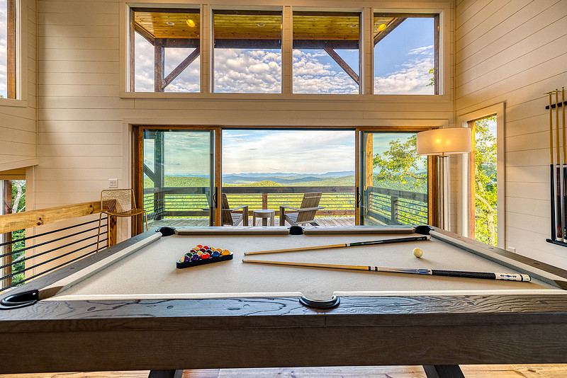 Game room with a pool table and a wall of windows, real estate photography in North Georgia
