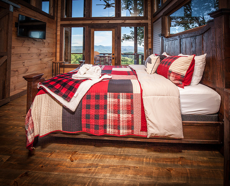 Primary bedroom with wood walls and a plaid quilt, real estate photography in North Georgia